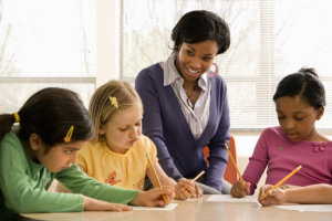 teacher guiding her students in writing
